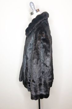 This is a faux fur, reversible jacket by Mackintosh, New England. The fur is soft and cozy and has the look of mink. The buttons look like horn and add a fun vintage flair. The reverse side is brown water resistant fabric, with fur trim. There is some creasing in the reverse fabric (see picture 7) which does not effect wearability. This is a stylish and very practical jacket, ready for whatever Mother Nature has in store. Size tag L. Check measurements carefully. Measurements taken with jacket l Vintage Faux Fur Coat For Cold Weather, Faux Fur Lined Mink Coat, Mink Faux Fur Coat With Faux Fur Lining, Mink Colored Faux Fur Coat, Vintage Outerwear With Faux Fur Trim, Fall Mink Color Fur Coat With Faux Fur Trim, Mink Faux Fur Coat, Brown Water, Peignoir Sets