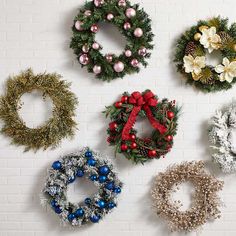 christmas wreaths hanging on a brick wall