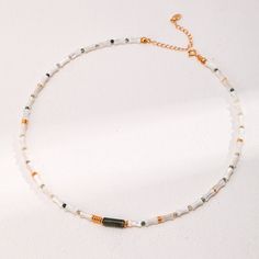 Wear the charm of mother-of-pearl with the organic elegance of bamboo-inspired beads and a Moss Agate bead in the middle. Each segment is crafted with precision, reflecting a dedication to the art of jewelry making and a tribute to natural beauty. Gemstone Type: Moss Agate, Mother-of-Pearl Length: 36.5cm+6cm Material: 18k Gold Plated on Sterling Silver Note: Every pearl is unique. Items may vary from the pictures. Spiritual Pearl Necklace With Natural Stones, Modern White Jewelry With Round Beads, Modern White Round Bead Jewelry, Nature-inspired White Necklace With Natural Stones, Adjustable Pearl White Jewelry With Colorful Beads, Modern Handmade Pearl Jewelry, White Jade Necklace With Natural Stones, White Jade Jewelry For Meditation, Bohemian White Jade Necklaces