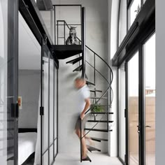 a person walking up the stairs in a room with glass doors and windows on both sides