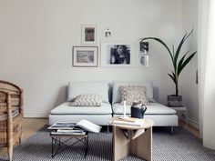 a living room with a couch, coffee table and pictures on the wall above it