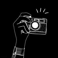 a person holding a camera in their hand with the light coming from it's lens