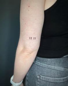 a woman's arm with the number 11 tattooed on her left arm, in black ink