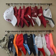 several hats are hanging on a rack in front of a wall