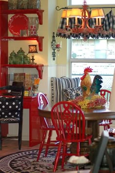 a dining room filled with lots of red furniture and decor on top of a rug