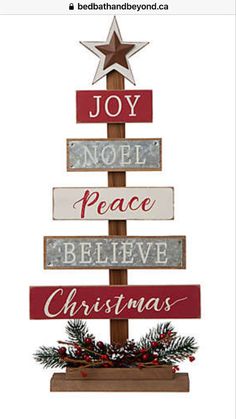 a wooden christmas tree with the words joy, peace, believe and christmas written on it