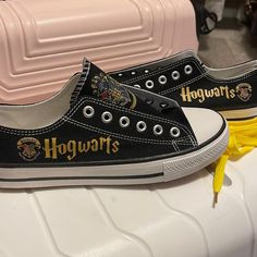 two harry potter shoes sitting on top of a white table next to pink suitcases