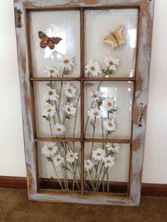 an old window is decorated with daisies and butterflies