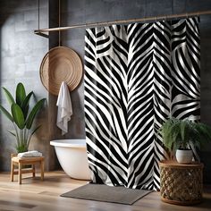 a black and white shower curtain in a bathroom next to a bathtub with a potted plant