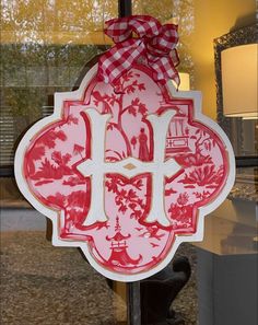 a red and white sign hanging from the side of a glass door with a bow on it