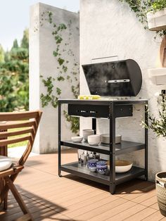 an outdoor bbq grill on a deck with potted plants