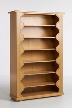 a wooden bookcase with curved shelves on one side and an open shelf on the other