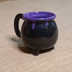 a black and purple mug sitting on top of a table