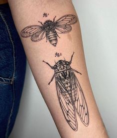 a woman's arm with a drawing of two bees on the back of it