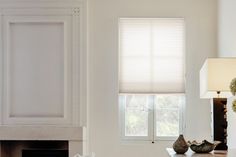 a living room filled with furniture and a fire place next to a window covered in blinds