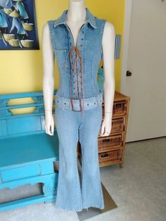 "Great condition retro denim jumpsuit, features zipper, suede lace upfront and belt with Metal Buckle. Flared pants. The label is 'Innocent' reads Medium however is a Small, the denim has about an 1\" stretch in fabric  Measurements: Shoulder Seams 4\" Neck 18\" round Collar 3\" wide Armholes 19\" clearance  Pocket 3.5\"wide x 4\" Deep Front Metal Zipper 17\" long Metal eyelets Suede Lace up Bust 32\"-34\" Waist 28\" Hips 34\" Belt 2.75\" wide, 45\" long Metal Buckle 3.5\" long, 2.5\" wide Crotc Fitted Denim Jumpsuit With Belt Loops, Fitted Denim Jumpsuit With Belt, Fitted Belted Denim Jumpsuit, Fitted Casual Belted Jeans, Casual Fitted Belted Jeans, Spring Fitted Denim Jumpsuit With Belt, Belted Fitted Denim Jumpsuit For Spring, Fitted Belted Denim Jumpsuit For Spring, Fitted Jumpsuits With Belt For Spring