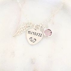 a personalized necklace with an angel wing, heart and baby feet on the front