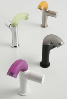 four different types of faucets on a white surface, one is black, one is yellow and the other is purple