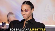 a woman with braids on her hair and wearing a black coat is looking at the camera