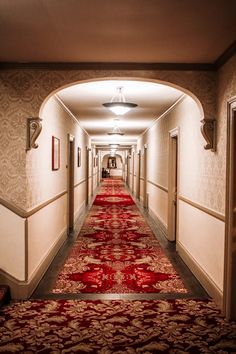 a long hallway with red carpet and white walls