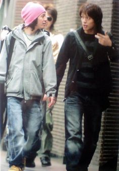 two young men walking down the street together