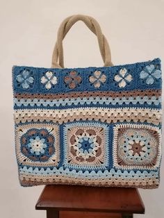 a crocheted bag sitting on top of a wooden table next to a white wall