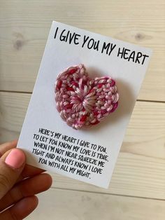 someone is holding up a card with a crocheted heart on it that says i give you my heart