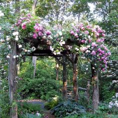 an arbor with flowers on it in the woods