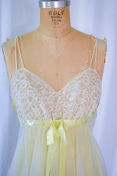 1960s Nightgown | Vanity Fair | Vintage 60s Floaty Citron Yellow and White Nylon Chiffon Nightgown with Lace Bust 32-34"  Sz. XS-S DETAILS: *1960s era *Citron yellow and white nightgown *White nylon chiffon over yellow nylon tricot *Floaty ballerina style *Gathered white lace bodice *Empire waist *Wide yellow satin ribbon bow *Spaghetti straps *Wide panel at waist *Gathered nylon chiffon back creating more sweep and fall *Scallop lace hem LABEL: Vanity Fair CONDITION: Very good condition. Some small dot/ marks - hard to photograph. Does not distract.  MEASUREMENTS:  Bust= 32-34" Waist= 28" Hip= 38" High Point Shoulder to hem=44" Compare with your own measurements + ease or compare with similar garments in your closet. SHIPPING: This item will ship via priority mail domestically and interna Vintage Fitted Nightgown For Party, Vintage Nightgown For Spring Party, Vintage Sheer Sleepwear For Evening, Retro Sleep Dress With Lace Trim, 1960s Nightgown, Chiffon Nightgown, White Nightgown, Ballerina Style, Satin Ribbon Bow