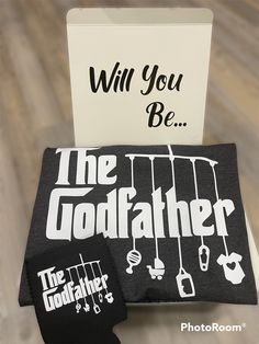 the godfather will you be gift card and wallet cover are on display in front of a greeting card