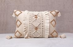 a white pillow with tassels on it