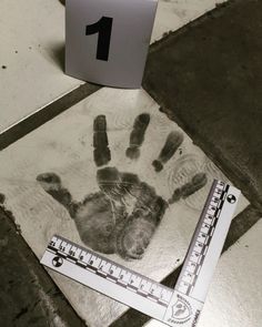 a piece of paper with a handprint on it next to a ruler and pencil