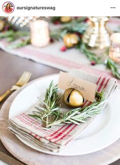 a place setting with pine cones and greenery