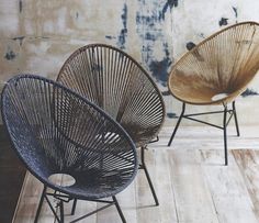 two chairs sitting next to each other on top of a hard wood floor in front of a wall