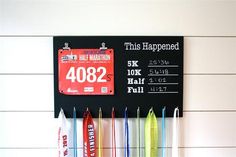 a black sign hanging on the side of a wall next to some markers and toothbrushes