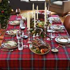 a table set for christmas dinner with plates and silverware