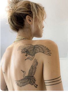 a woman with a bird tattoo on her back