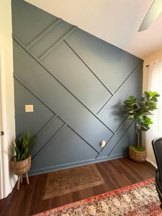 a living room with blue walls and wooden flooring in the corner, along with a rug on the floor