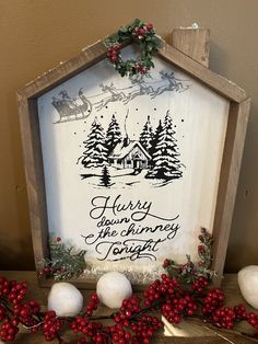 a wooden sign with christmas decorations and berries on the table next to it is an ornament