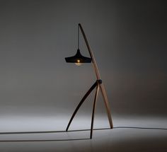 a lamp that is on top of a wooden stand with a light in the middle