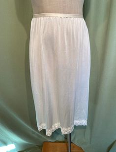 "This is a lovely, vintage half slip. Labeled, \"St. Michael, Marks & Spencer\" Tagged a UK size 16-18, Long which is a US size 12-14. Waist measures 26\" to 34\", see measurements below. Made of white polyester. It has a pretty lace hem. The waist is elastic. Condition is very good! No wear or tear. No soil or stains. Sweet! Please measure yourself & know your measurements before buying! Please remember that vintage sizes run small. It is best to measure yourself, or a similar garment that fits Vintage Summer Skirt For Daywear, Vintage Bottoms With Lace Trim For Summer, Vintage Lace Trim Bottoms For Summer, Summer Daywear Lined Petticoat, Vintage Summer Petticoat With Lined Skirt, Vintage Lace Trim Skirt For Summer, Vintage Petticoat For Summer Daywear, Vintage Lace Trim Petticoat For Summer, Vintage Lace Trim Slip Dress For Night