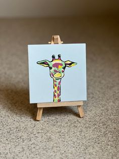 a painting of a giraffe is on an easel