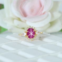 Star Ruby Women's Promise Ring, Elegant Bridal Ring, Birthday Gift For Wife, Delicate Moonstone Ring, Yellow Gold Plated, Art Deco Ring Maine Stone - Ruby (Lab Created) Stone Shape - Oval Stone Color - Pink  Stone Size -  8x6 mm Birthstone - July Secondary Stone : CZ Diamond Stone Shape: Round Stone Color: Colorless Third Stone: Moonstone  Stone Shape: Pear Stone Color: Blue Fire  Features: * Handmade * Ready To Ship * Brand New * All Ring Sizes Available * Suitable For Every Day * 14k Solid Gold / 18k Solid Gold / Gold Filled Over Sterling Silver * Purity Stamped * Fits True to Size * High Quality * Available Color: Rose Gold, Yellow Gold, White Gold ✦ feel free to contact me if you have any questions or you are interested in bulk order or custom order. ✦ Gemstone color may slightly vary Pink Opal Ring With Accent Stones As Gift, Pink Ruby Halo Ring Perfect For Gift, Pink Ruby Ring With Halo For Gift, Gift Pink Ruby Halo Ring, Gift Pink Halo Ruby Ring, Star-shaped Gemstone Rings For Gifts, Pink Moonstone Promise Ring, Ring Elegant, Fire Features