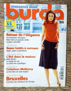 the front cover of a magazine with a woman in orange shirt and black skirt on it