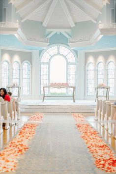 the ceremony aisle is decorated with orange petals