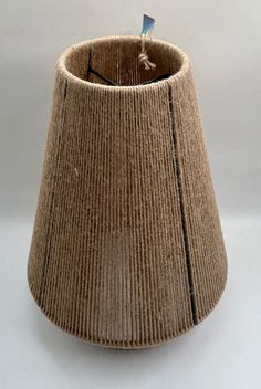 a brown corded lamp shade sitting on top of a white table