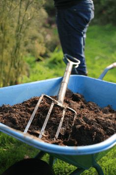 a wheelbarrow full of dirt with a person in the background