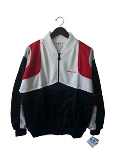 "80s adidas track jacket. black, white, & red. side pockets. metal logo zipper pull. embroidered logo on chest. 26\" long. 24.5\" across. 27\" sleeves. in excellent, unworn condition. legit. legitvintage.etsy.com legitvintage on instagram" White Long Sleeve Track Jacket With Adidas Logo, White Long Sleeve Adidas Track Jacket, Adidas Track Jacket With Logo For Fall, Crew Neck Outerwear With Three Stripes For Streetwear, Coveralls Mens, 90s Sport, 80s Adidas, Adidas Vintage, Adidas Track Jacket