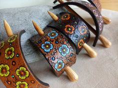 three wooden bracelets with colorful designs on them