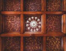 a decorative glass window on the ceiling in a room with wooden paneling and wood trimming